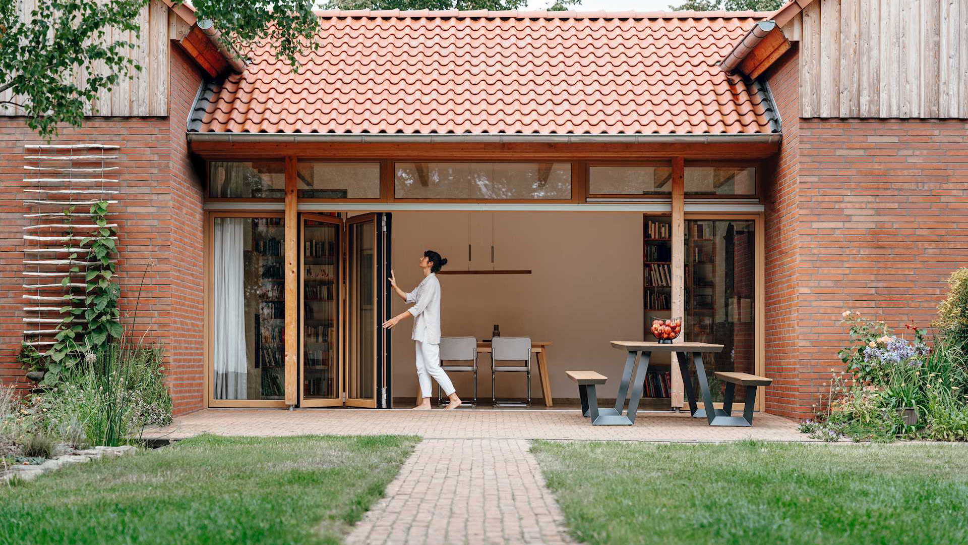 Frau öffnet eine Glas Faltwand aus Holz