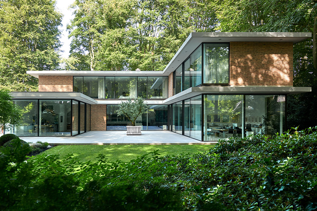 Kubisk villa med fasad av glaspartier från Solarlux.
