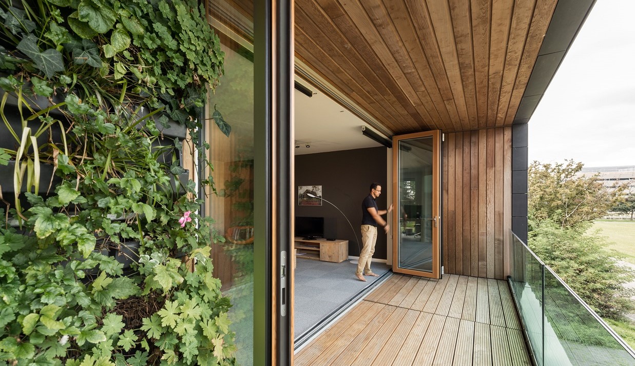 Een man opent de glazen vouwwand voor een royale gevelopening