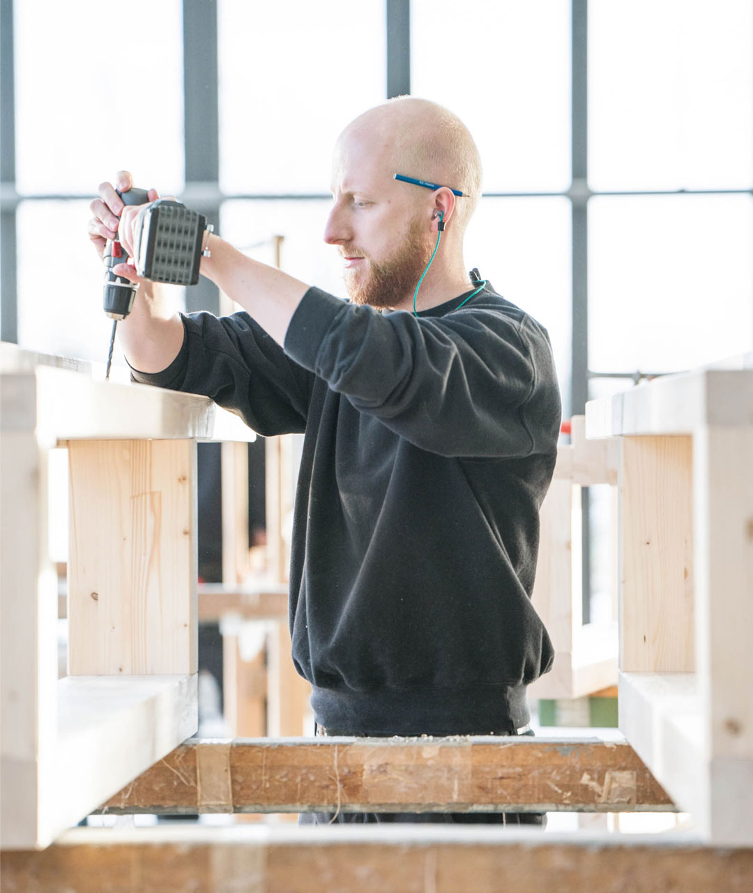 Solarlux medewerker boort bij de productie van hout vouwwand