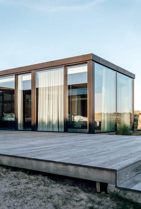 bodentiefe cero Schiebefenster mit Vorhängen verbaut in einem Strandhaus