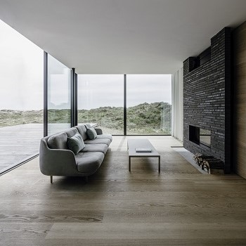 Skydedøren cero III fra Solarlux giver en åben udsigt over stranden og havet i en moderne villa.