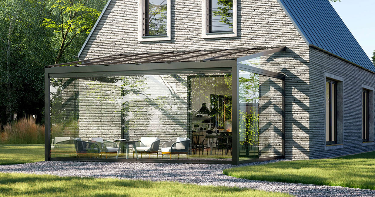terrasstak med glasfasad monterat på stort, grått tegelhus.