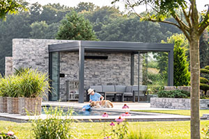 Solarlux udestue med fladt tag ved siden af en swimmingpool. 