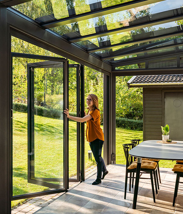 Isoleret udestue med foldbare glaspaneler skaber mere socialt rum i hjemmet. 