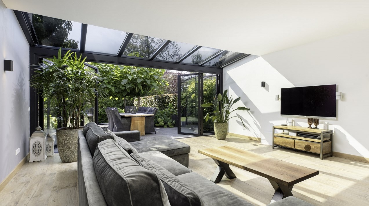 Förlängd vardagsrum med trägolv och glastak SDL Akzent plus från Solarlux. 