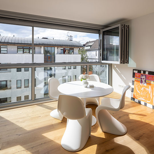 moderne Sitzgelegenheit vor einer geöffneten Solarlux Glas-Faltwand Highline modular