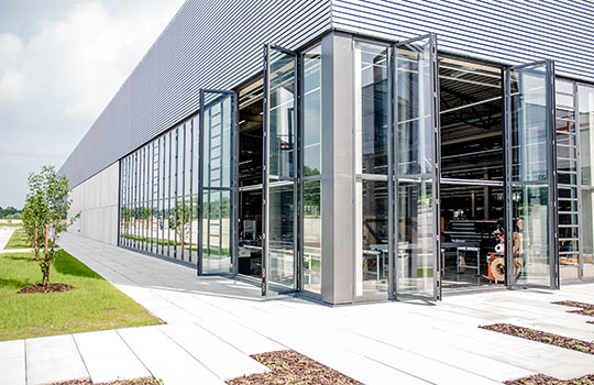 geöffnete Glas-Schiebewände einer Solarlux Produktionshalle