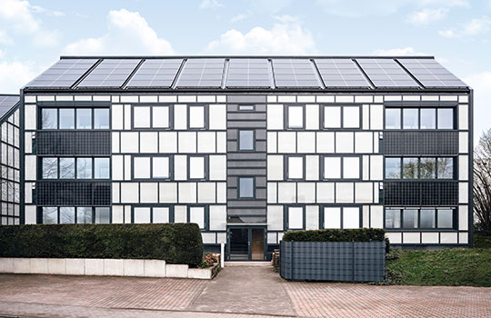 hochmodernes saniertes Haus mit Solarplatten auf dem Dach und Glas-Schiebetüren