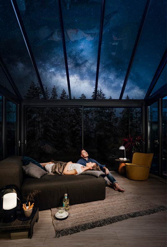 Paar im Wintergarten unter Nachthimmel