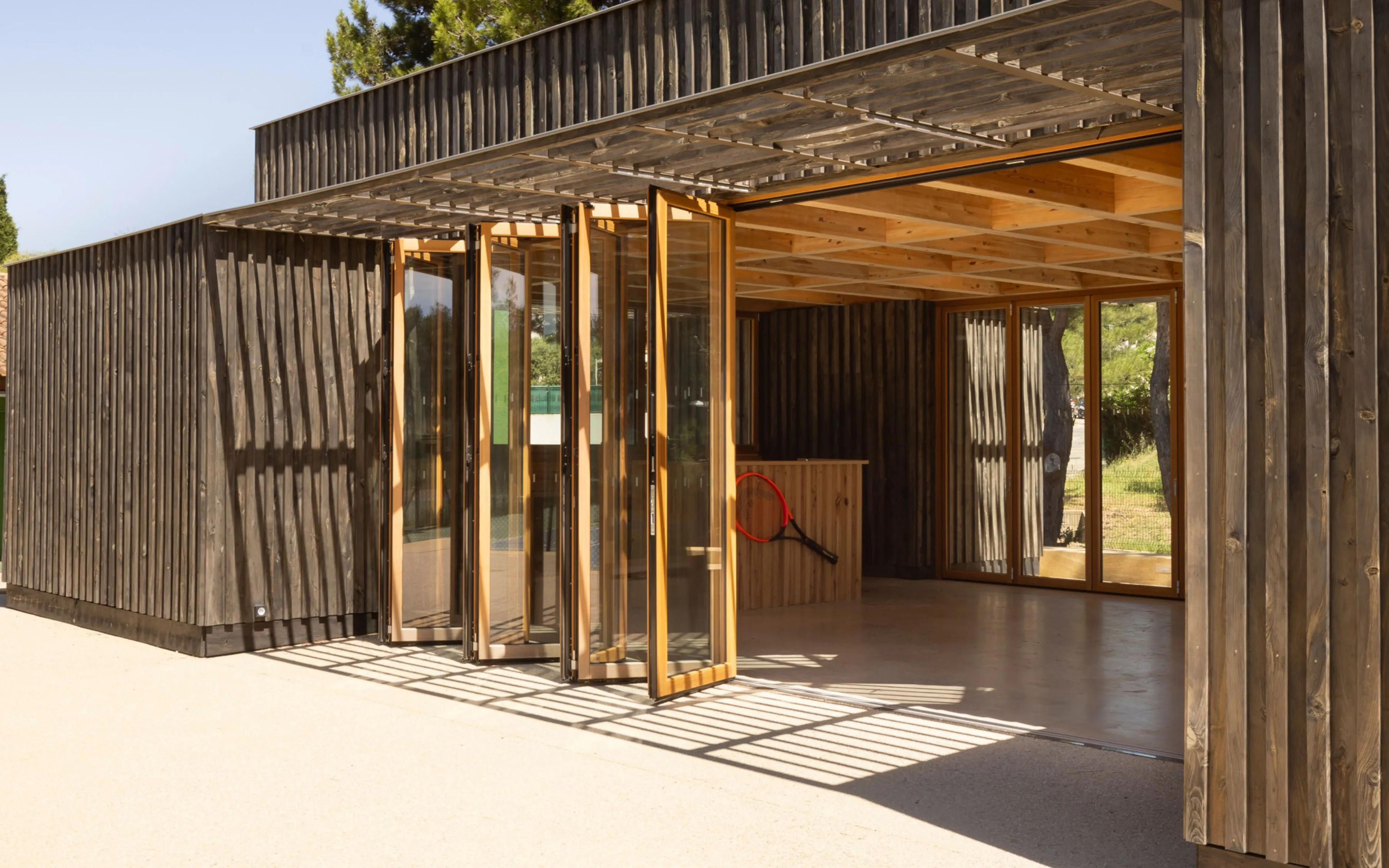 Baie accordeon en bois red grandis par Solarlux à motié ouverte