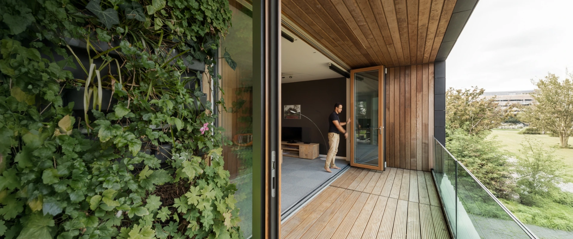 Man opens bifolding door - Combiline on the balcony