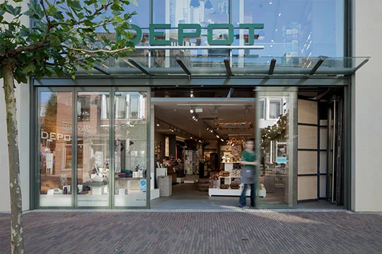 Verkoper opent de glazen schuifwand van een winkelingang om klanten binnen te laten