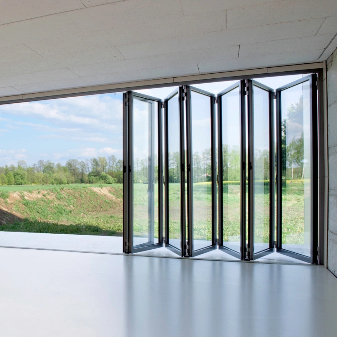 Foldedør i sommerhus med udsigt til have.