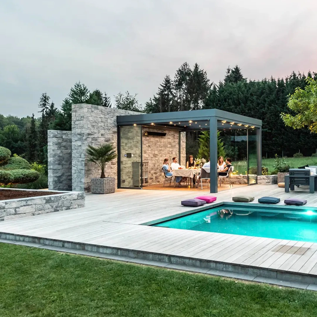 Fristående uterum mot en feature wall i sten skapar en underbar uteplats. 