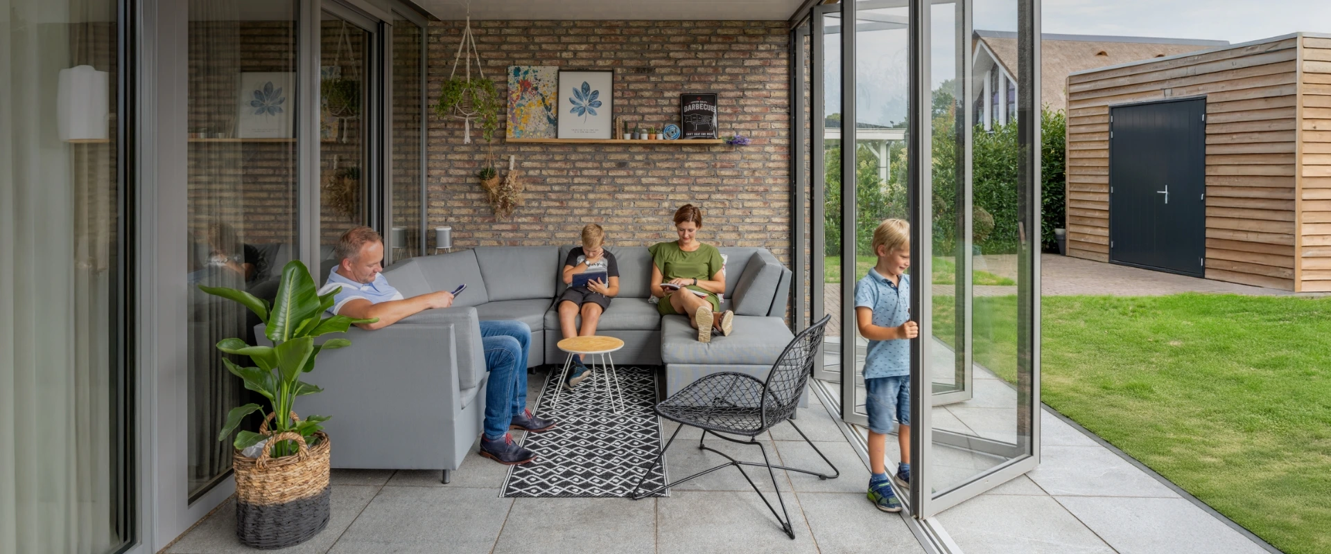 a family i sitting next to an opned bi folding door SL 45