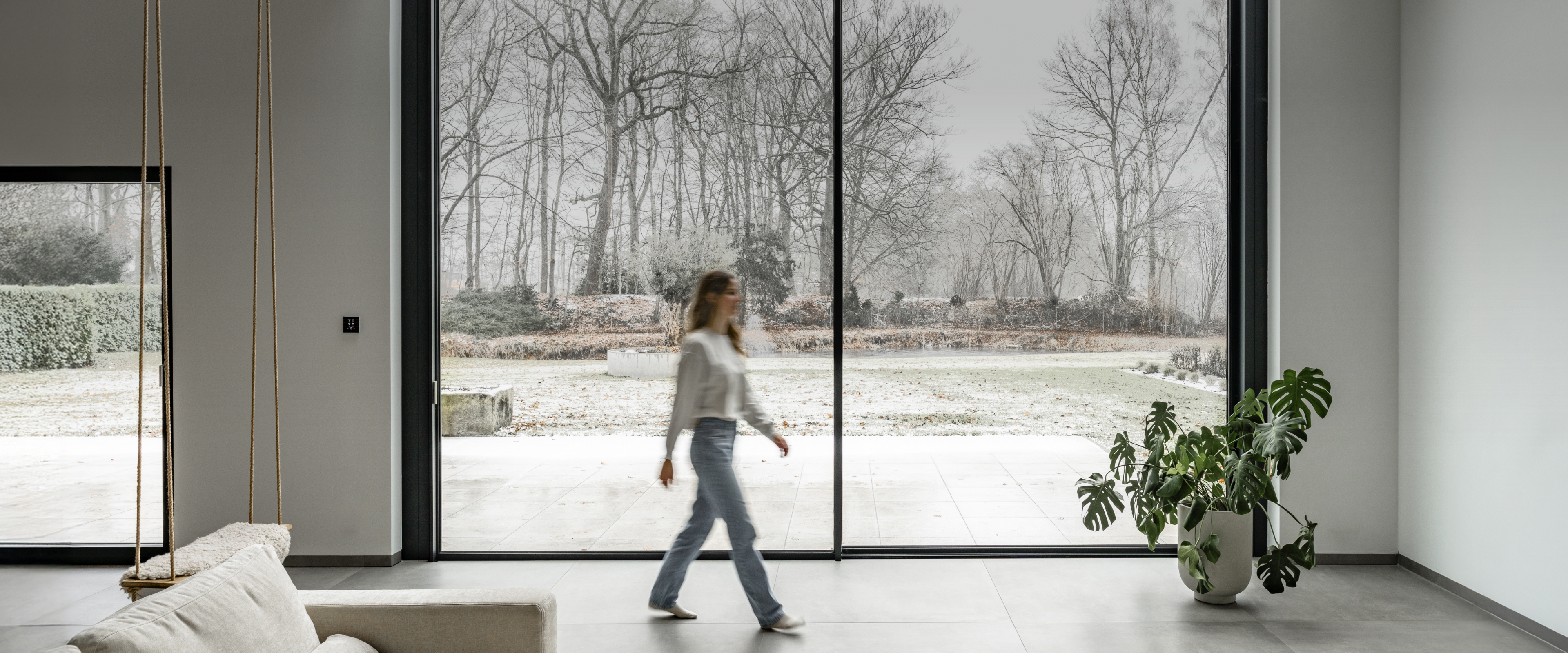 Gemütliches Wohnzimmer mit Wintergarten und Blick auf den Wald