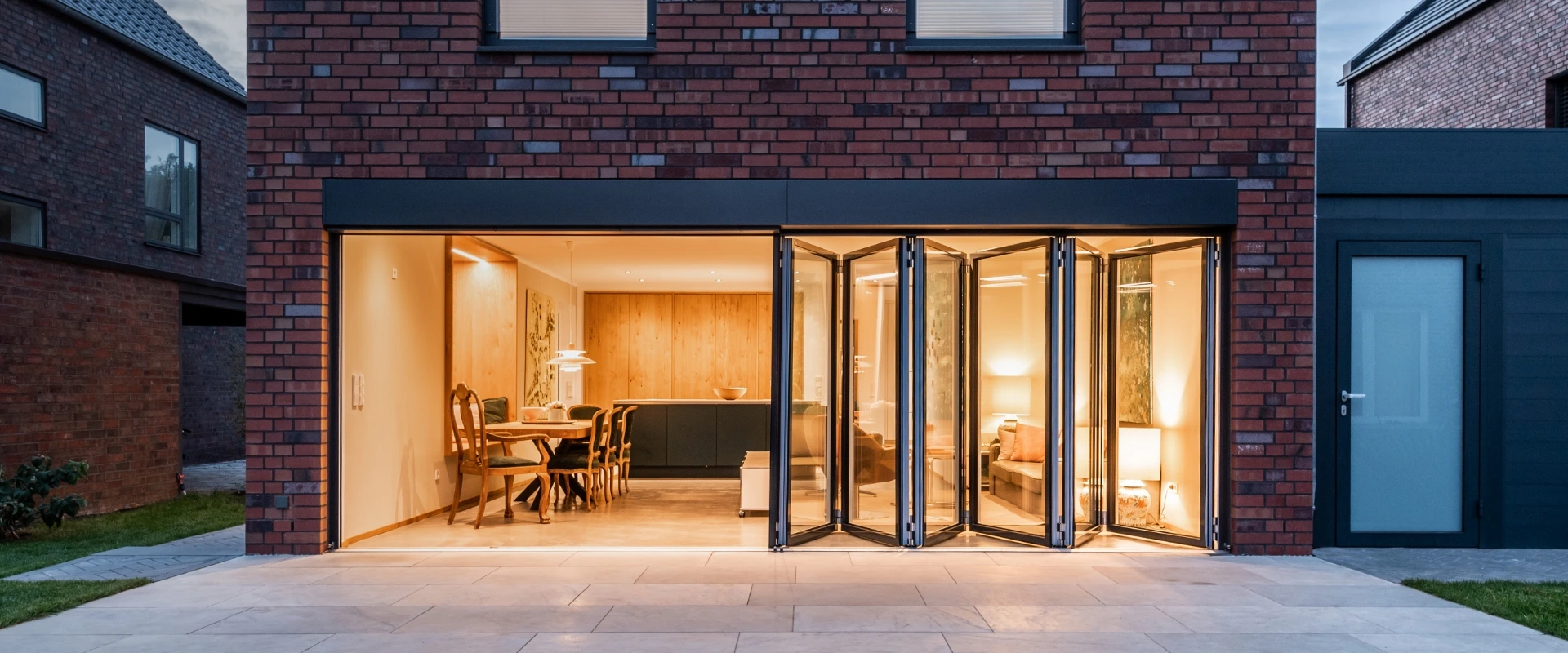 Wohnzimmer mit geöffneter Glas-Faltwand Highline aus Aluminium 