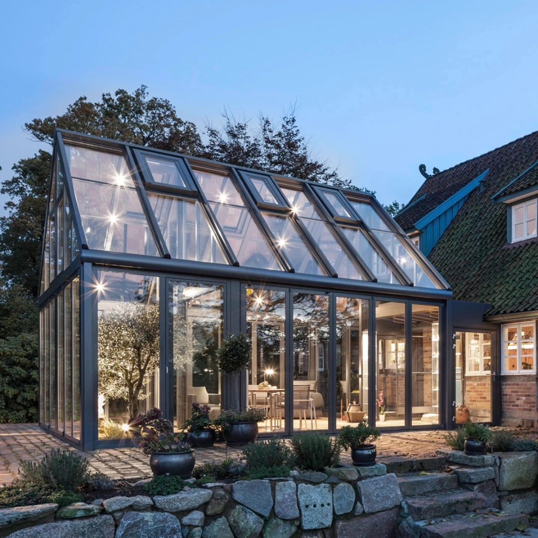 Isolerad vinterträdgård som fristående konstruktion intill en historisk byggnad.