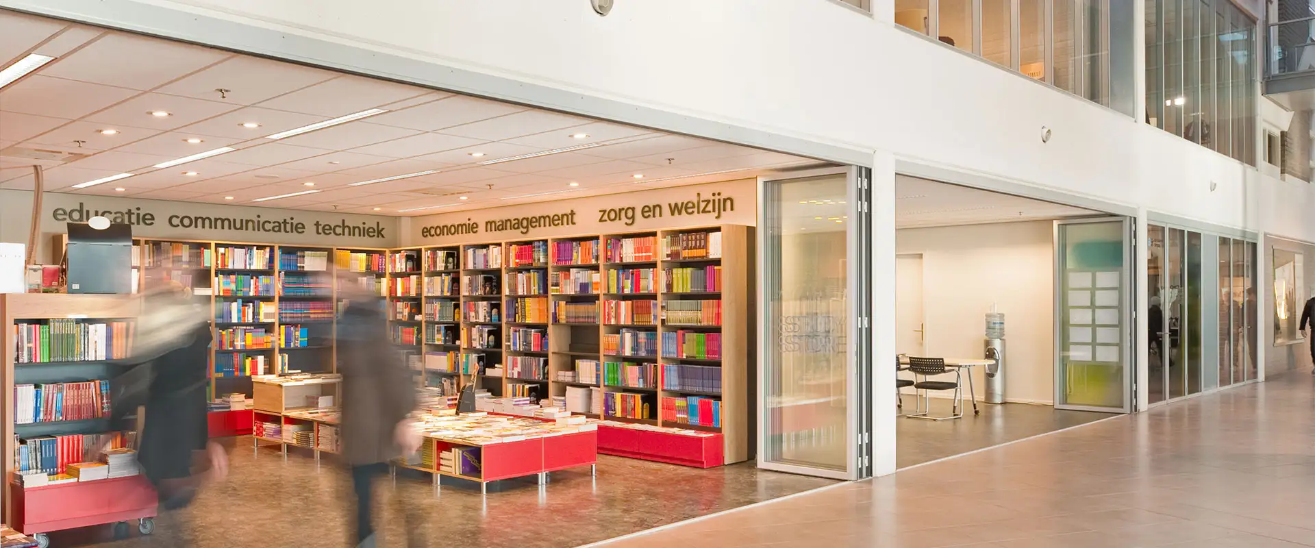 Bibliothèque avec une baie vitrée pliante ouverte servant d'entrée
