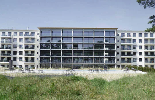 Moderne hotelgevel met cero-schuiframen en een zwembad op de voorgrond