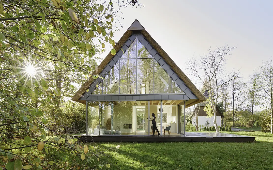 Moderne skovhytte med store glasvinduer. 