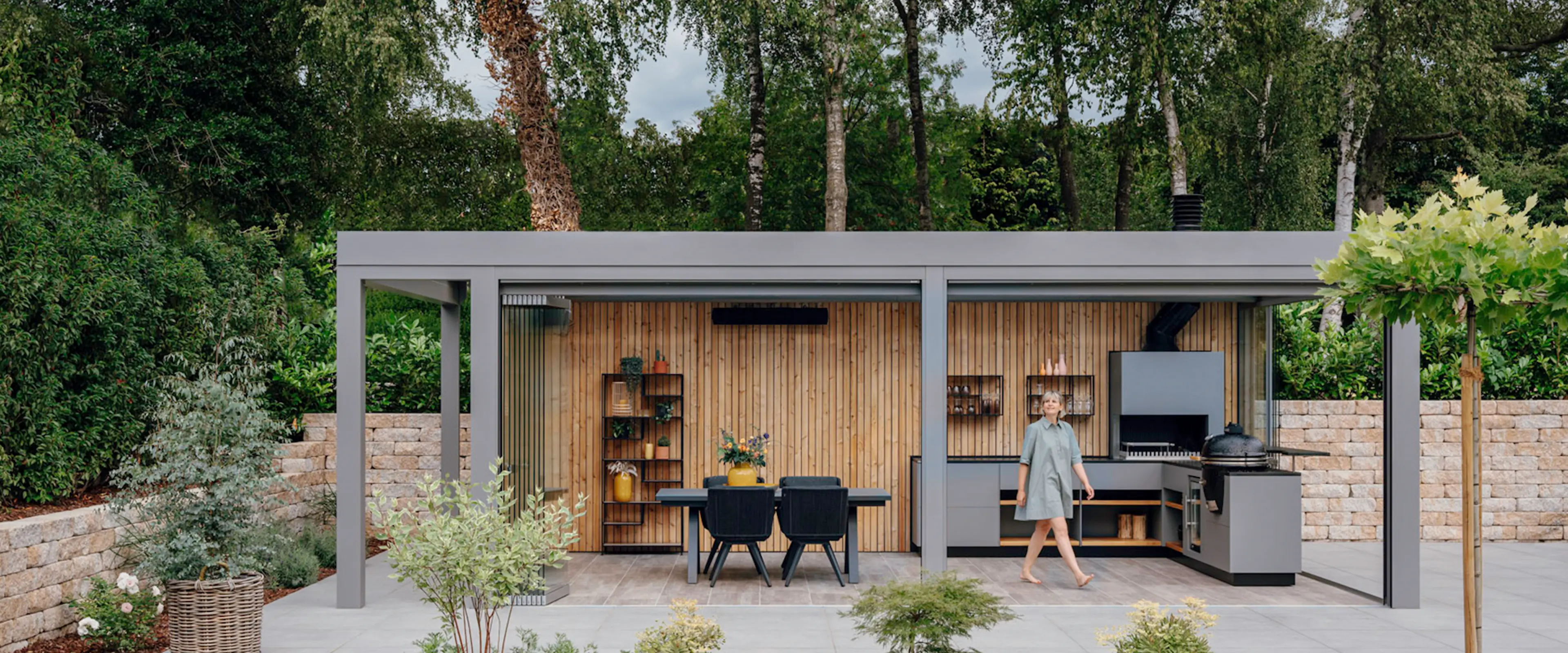 Stor udestue med fladt tag, der dækker udekøkken og spiseplads. 