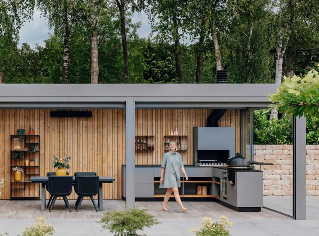 Stor udestue med fladt tag, der dækker udekøkken og spiseplads. 