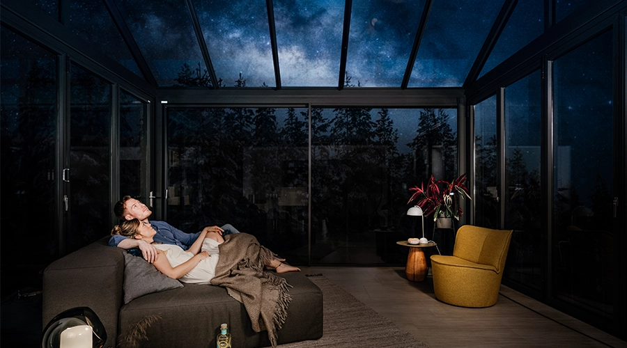 Vinterhave med glastag, der viser en stjerneklar himmel.