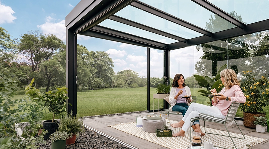 Solarlux-udestue indvendigt med frodig have udenfor. 