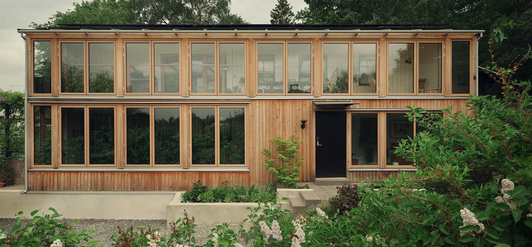 Stor udestue i træ med foldedøre foran. 