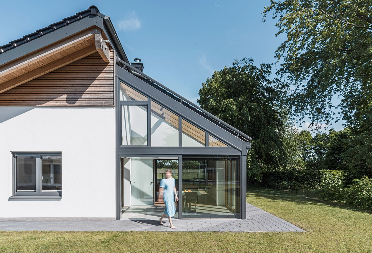 Solarlux udestue i aluminium og træ ved siden af en moderne træfacade.