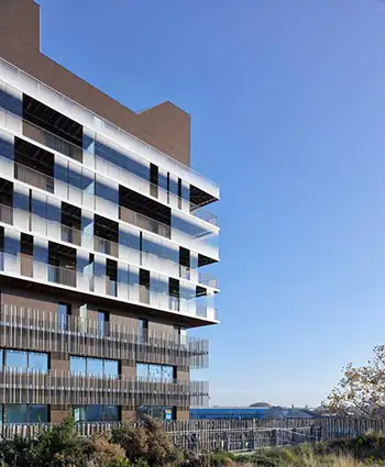 Lejlighedsbygning set fra afstand, som har skydedørssytemer, der er placeret på bygningens altaner.