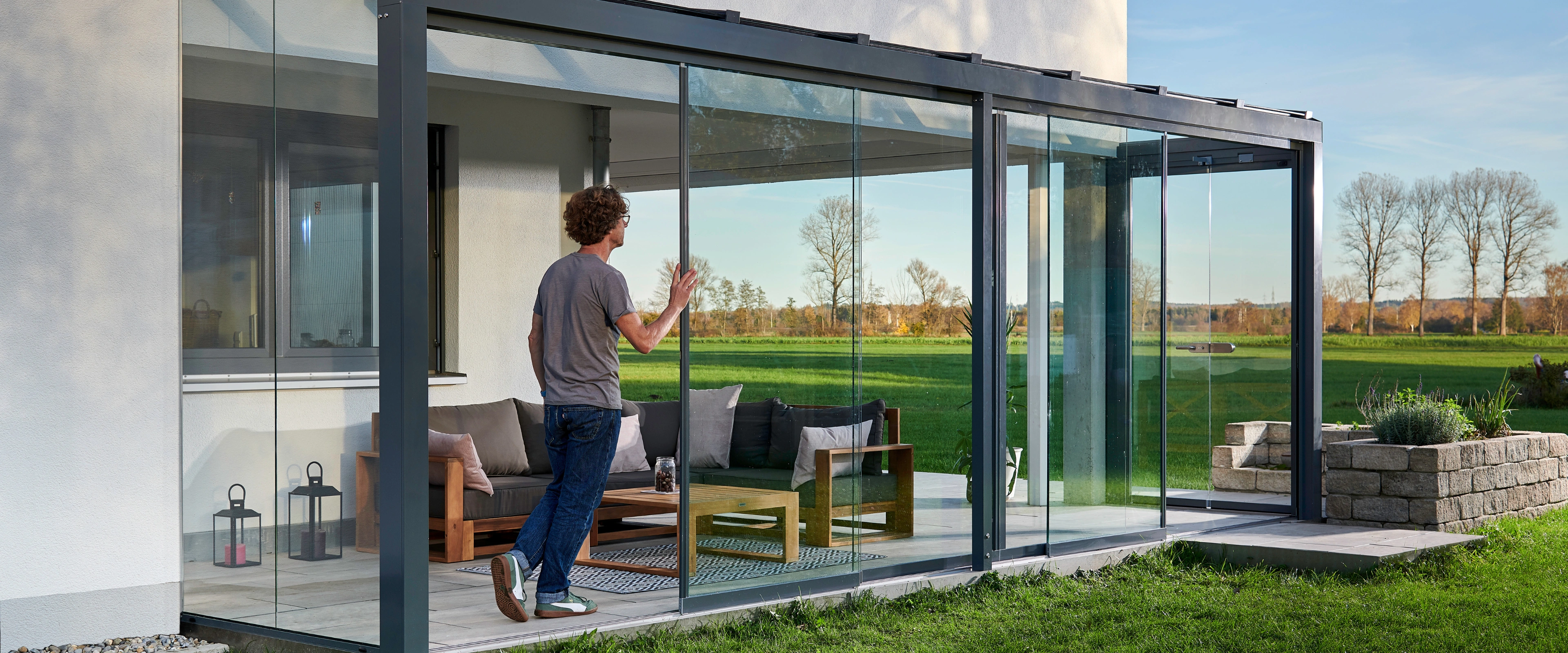 Åben og elegant udestue i glas fra Solarlux der åbner op for terrassen
