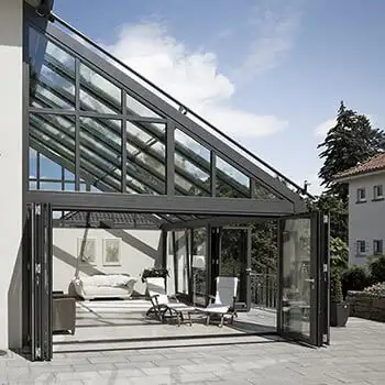 SDL Akzent Plus varmeisoleret vinterhave med konstruktion af aluminium og varmeisoleret glastag og vægge samt foldedør, som åbner op til terrasse.