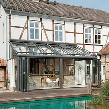 SDL Nobiles varmeisoleret vinterhave med skråt glastag og foldedøre af glas, som åbner op til terrasse og pool. Glastaget i denne vinterhave kan åbnes op på varme sommerdage for at lade luft og lys strømme ind.